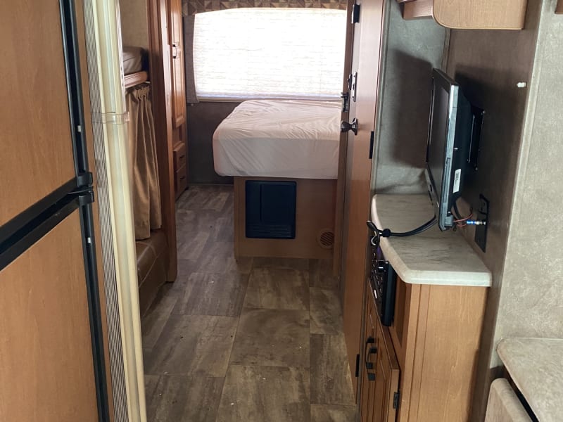 Mid room has a bunk bed/sofa and TV, storage cabinets, and provides access to the bathroom.  It has an accordion door for privacy.