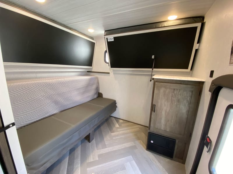 Back bunks sleeps 4, with 2 small bunks on top, and 1 double on the bottom, folds up so the kids/guests have a private area, access to extra storage.