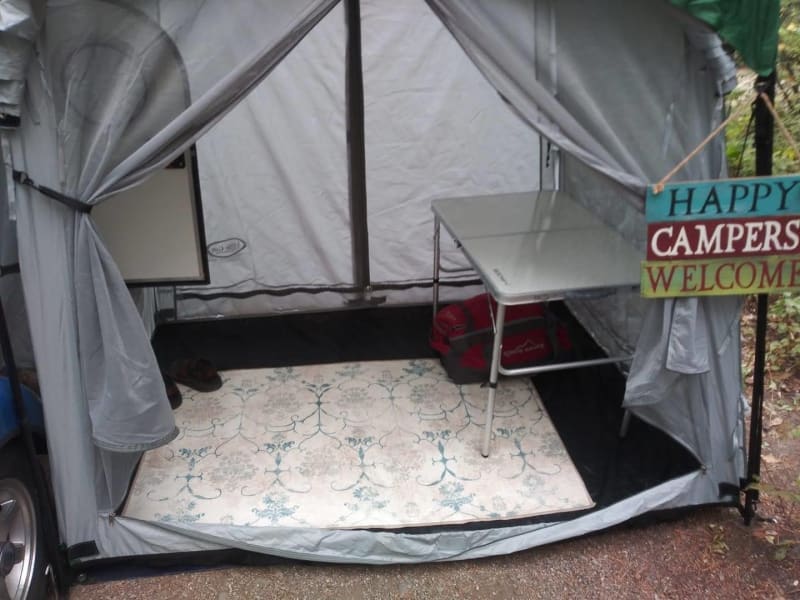 The side tent hooks right over the door of the trailer. It can be a screen room or a completely private room.