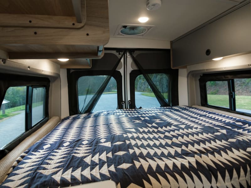 Queen-sized bed; storage cabinets that stay open through magnets on the ceiling; blackout shades on all windows/back doors are easily zipped up. 