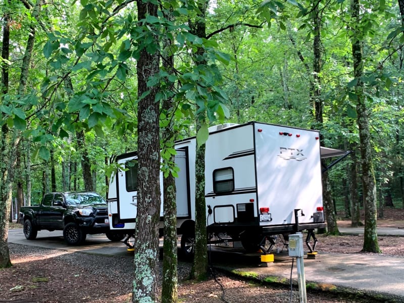 View of the exterior of the camper from the rear, pop-out visible.