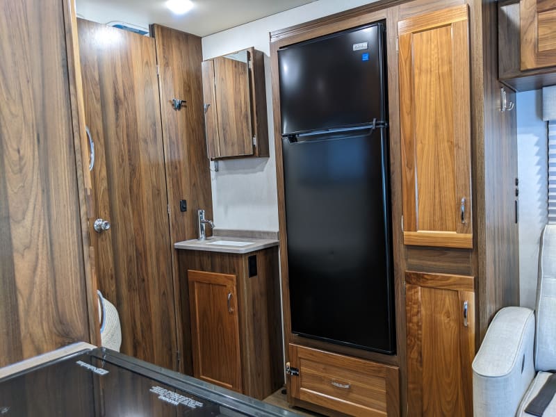 Look how big that refrigerator is!  There is way more storage and a vanity outside the bathroom with a medicine cabinet too.  