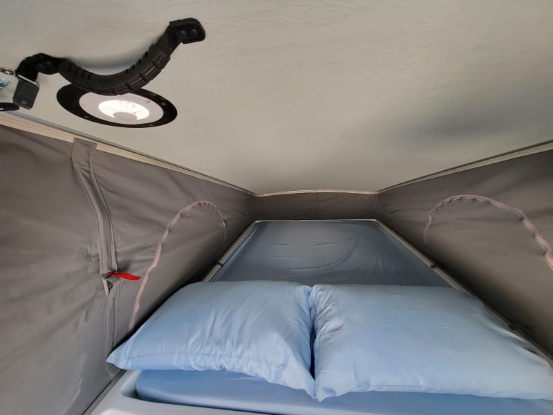 Popup sleeping area with sheet and pillows.  Please provide your own sleeping bag for here.