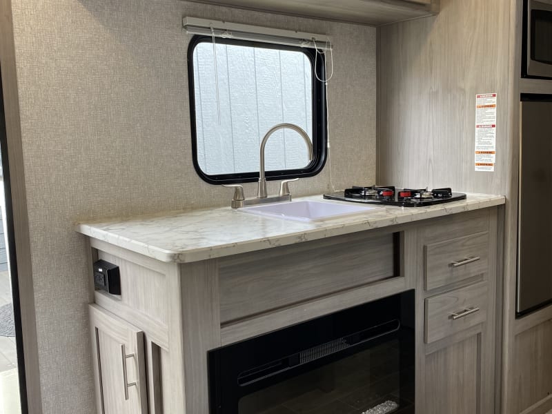 Kitchen sink, two propane burners, and gas fireplace heater. 