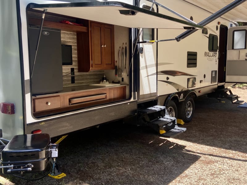 Outdoor kitchen. 
Mini fridge 
Propane BBQ 
Sink 
Pull out counter space 