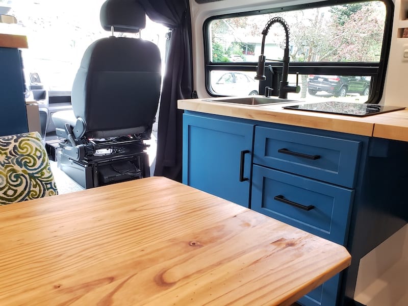 Kitchen sink and induction stove. Microwave is located above the dinette.