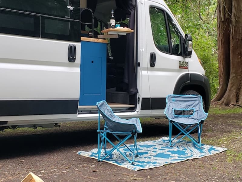 Campsite set up. Has a backup camera, electric hookup, and water hookup. Firewood and camp chairs can be added on.