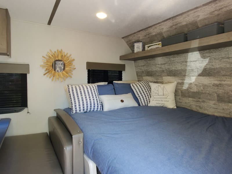 Bed w/down comforter, 4 standard pillows, decorative pillows, extra storage bins, wall hanging & linens featured in the Glamping Package Addon