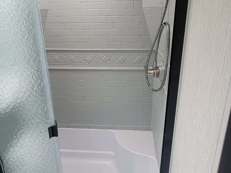 Frosted glass shower door, and a sunlight for natural light during the day. Does not feel like you're showering in a camper! Super modern & spacious!