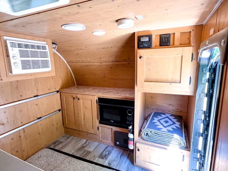 Inside the RV you'll find your microwave, stereo, storage space, couch/bed and optional dining table that's stored in the floor when not in use. 