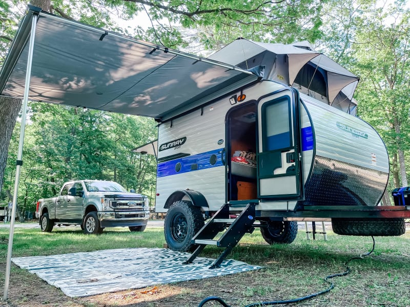 The awning offers shade and shelter from the rain. Outdoor mat is included.  