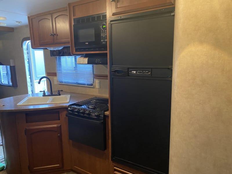 Kitchen with double sink and 3 burner stove. 
