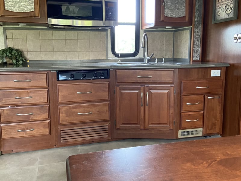 Solid wood cabinets. Large Double bowl sink. convention microwave. Pull down faucet. Corian countertops.  
