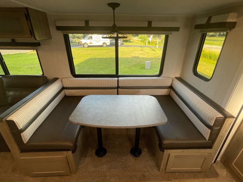 U-shaped dinette with large, bright windows that open for a gentle breeze. Crisp and clean leather seating. Folds down into another space to sleep. 