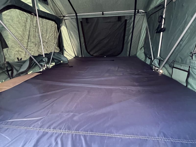 showing the queen-sized camp mattress in the rooftop tent.