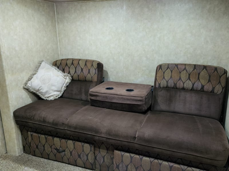 Couch in bunk room has fold-down armrest with drink holders.
