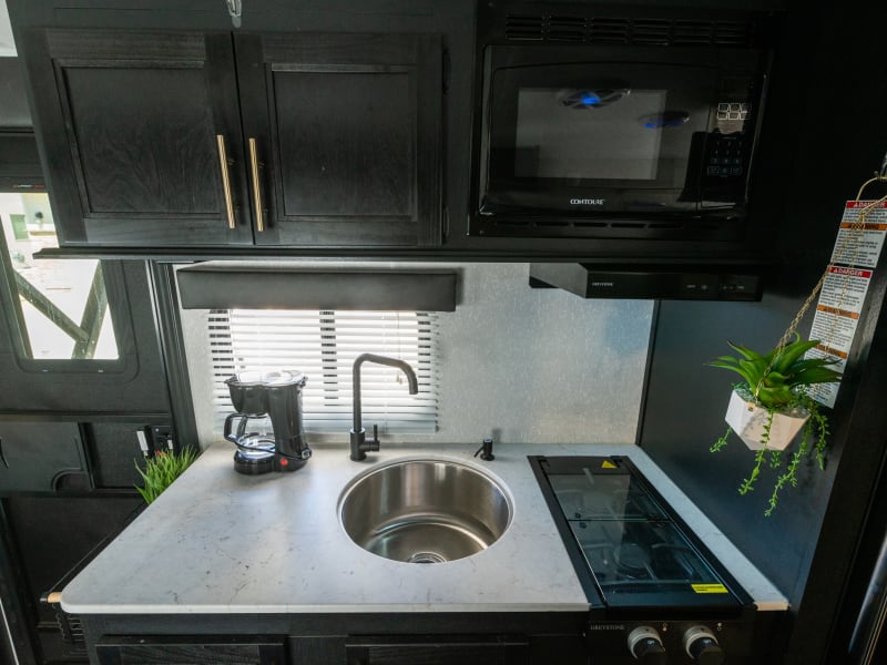 Kitchen provides a microwave, 2 burner stove, generous sink. When the sink and stove covers are in place it provides a decent sized prep area.