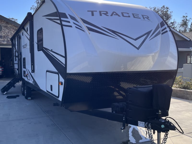 The aerodynamic front cap with a power tongue jack and dual propane setup enhances towing ease and curb appeal.