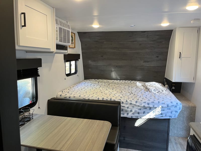 Queen size bed at the forward area of the camper hides storage inside. The dining table turns into a bed that would be comfortable for children. 