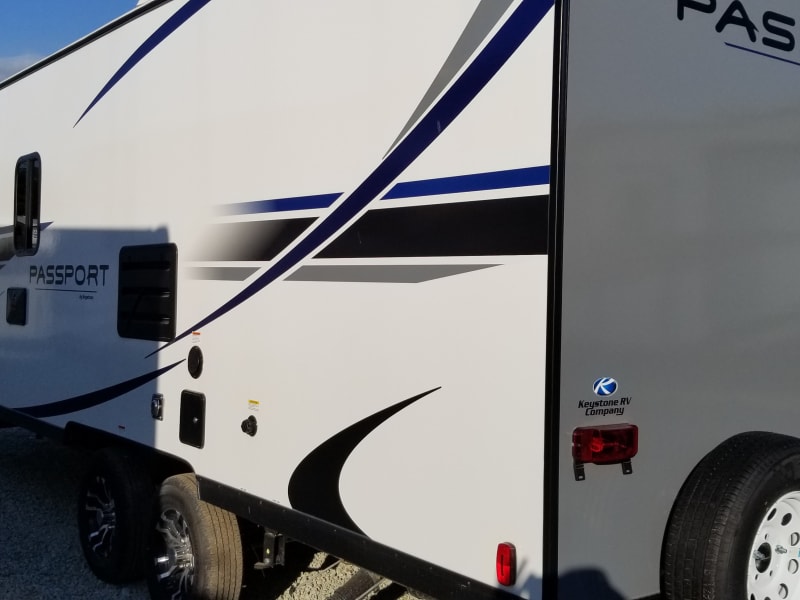 Back of camper has an exterior hot water shower. 