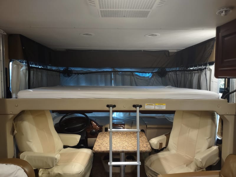 spacious bunk above driving area drops down over lounge