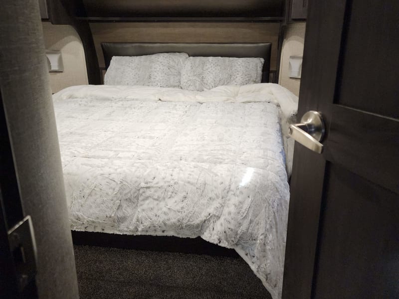 Queen size bed the  bathroom with shower has door connected to it and plenty of storage area