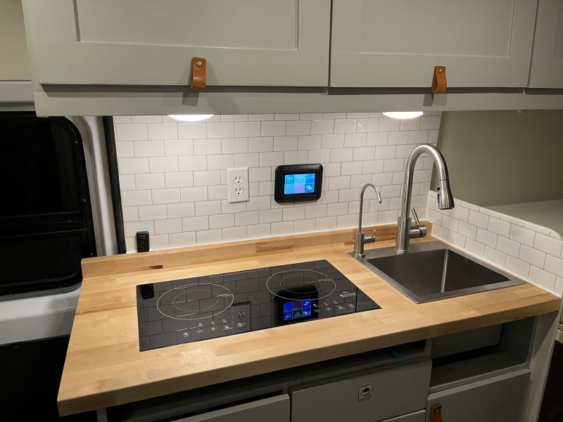 kitchen counter top with induction oven and sink with filtered water spout