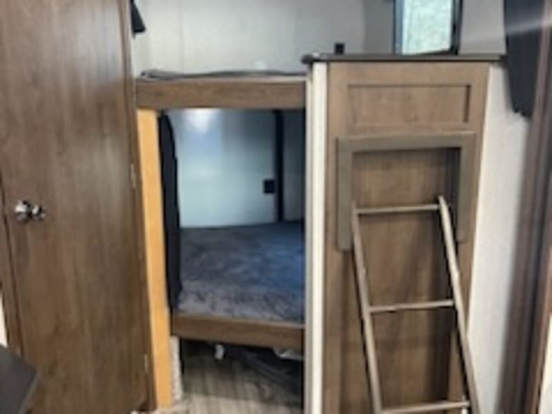 Cozy bunk area with privacy curtains. Ladder slides back in for more room!