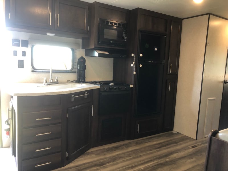 Modern kitchen with fridge, stove, and microwave. 