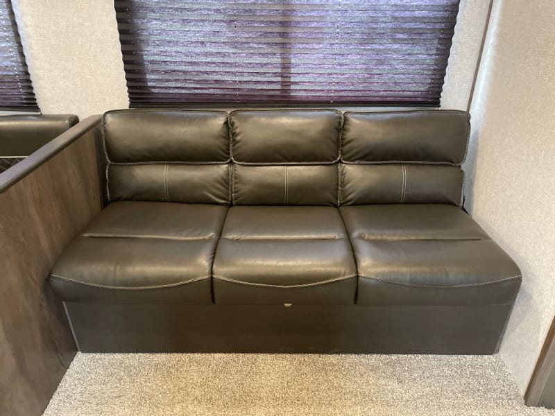 This couch fold down to a bed. It also has a flip down cup holder/arm rest in the center cushion and there’s storage underneath 