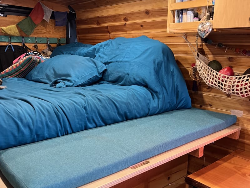 Slide out bed. Suitable for under 70lbs. Not pictured is a railing that protects from rolling off the bed. 
