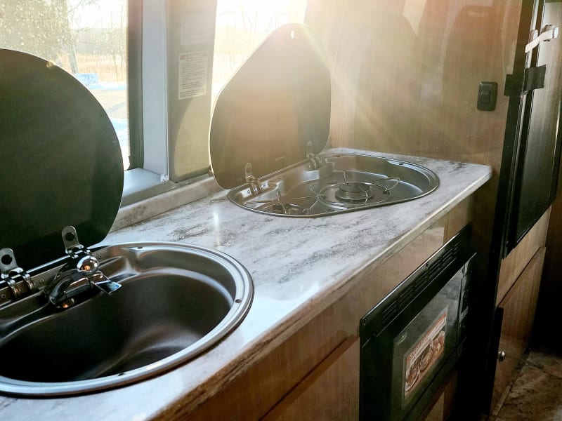 This clever setup provides ample counter space for you to prepare that good breakfast. Flip up the covers and discover a cooktop and sink !