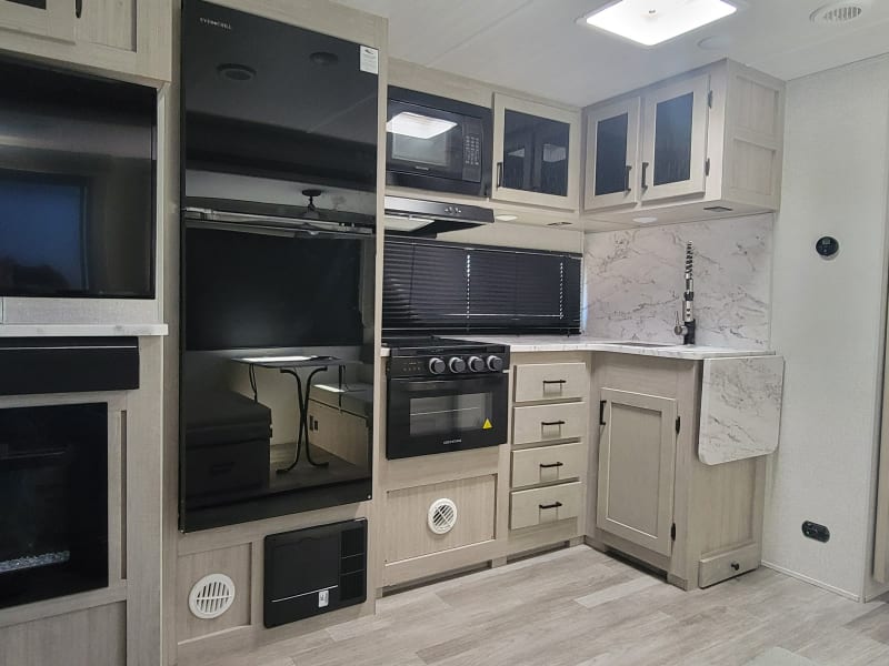 Large 12v fridge with three burner stove and digital oven. 