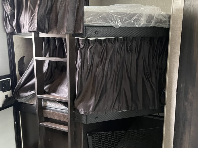 2 full size bunk beds with curtains 