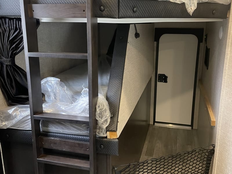 Bottom bunk folds up and has access to outside 