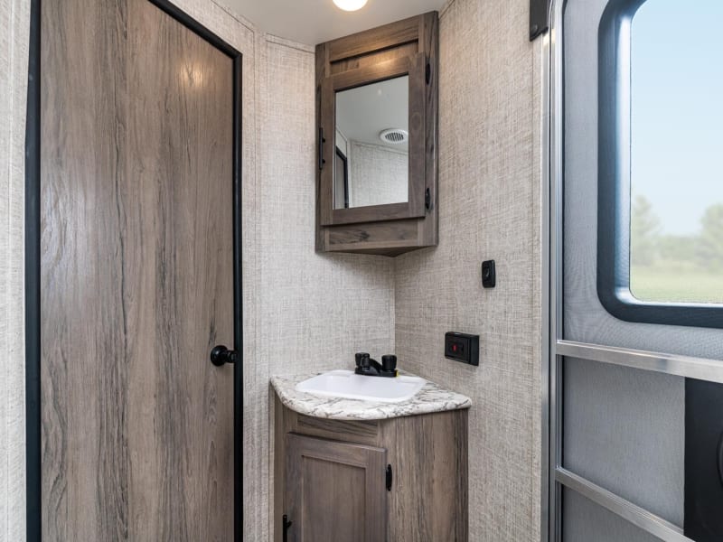 Bathroom has medicine cabinet over sink, with storage below. 
