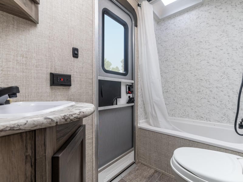 Large bathroom with separate entrance and shower over tub