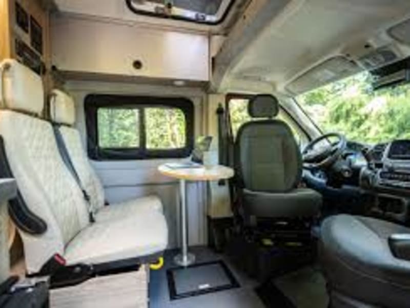 Front seats rotate to make a dining area for four and aircraft style cabinets line the RV on both sides for plenty of storage.