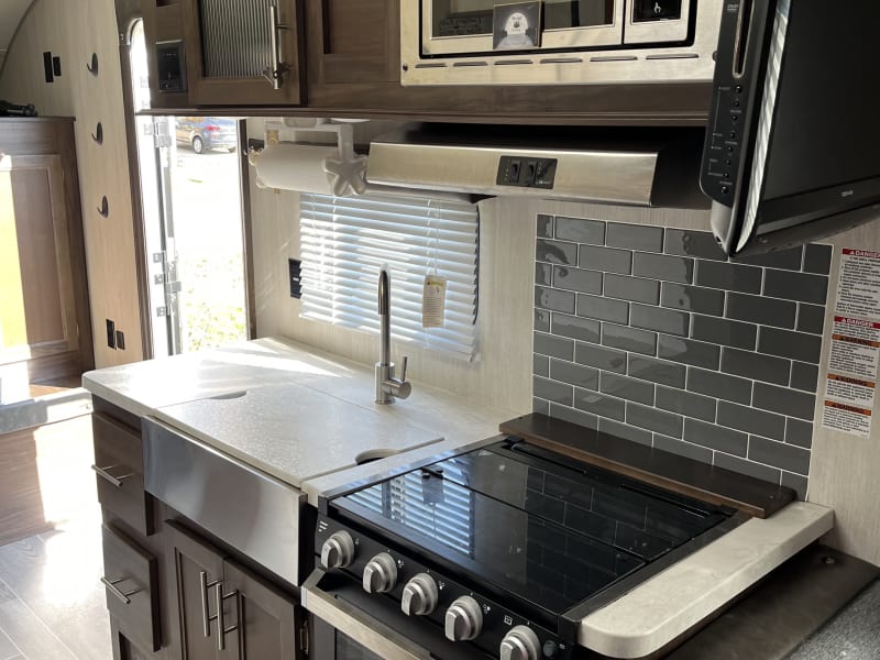 Spacious farmhouse sink, 3 burner cooktop, oven, and microwave. 