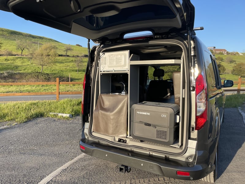 Hand pump sink, 25L Dometic fridge, and upper storage shelf