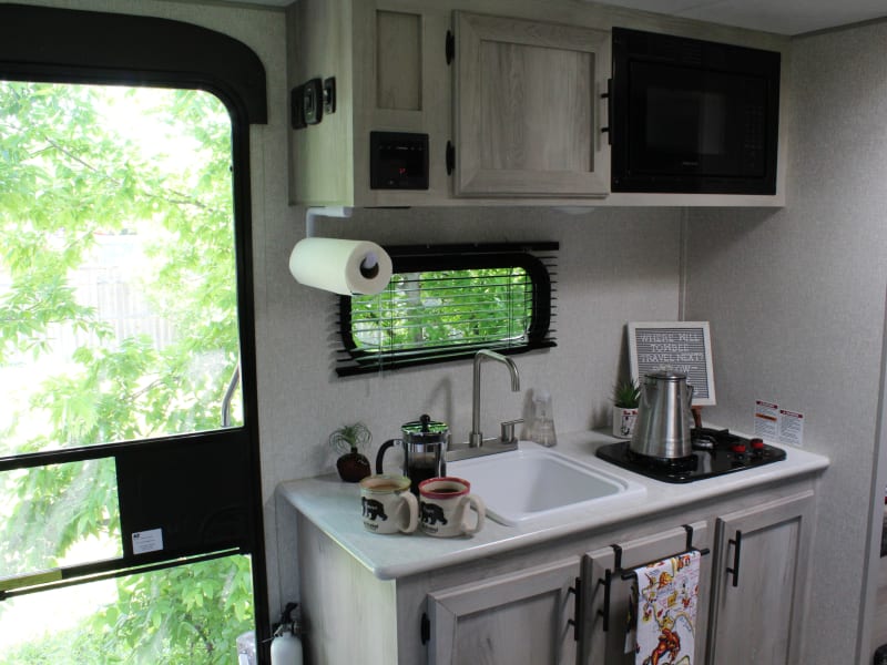 The kitchen is stocked with paper plates and plastic utensils, as well as dish rags and wash cloths. 