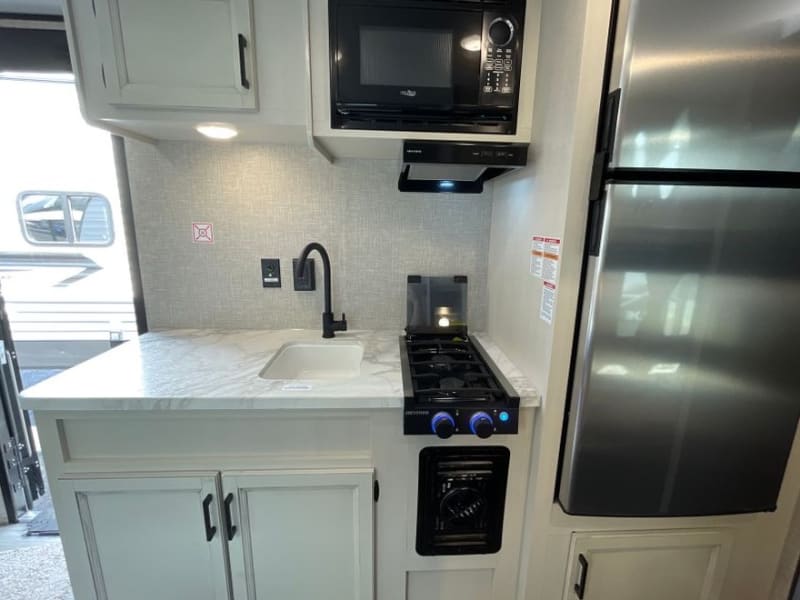 Kitchen with lots of counter space! high rise faucet, microwave oven, 2-burner stove top.