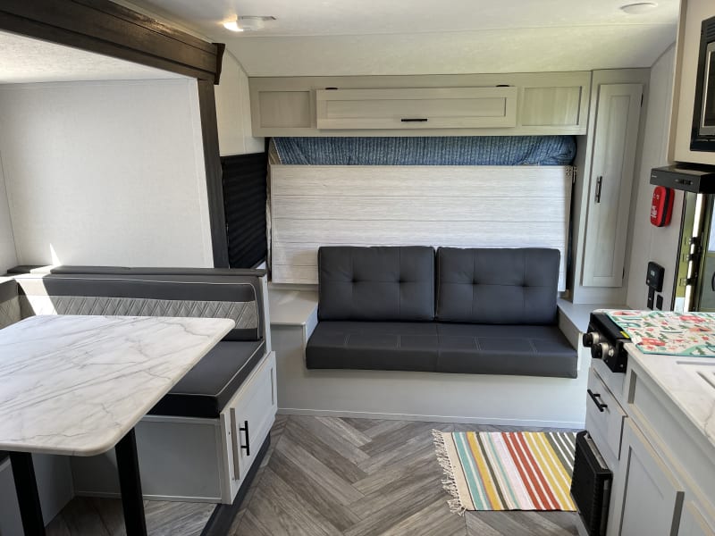 Queen Murphy bed folds down over the couch. Overhead cabinet and side cabinet with hanging rod provide storage.