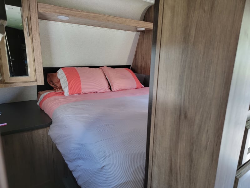 Queen size bed in bedroom at the front of the camper