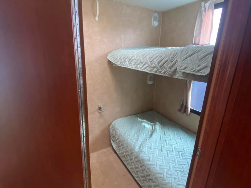 Second bedroom is a private bunkbed room with TV, 3 drawer dresser and more storage under the lower bed. 