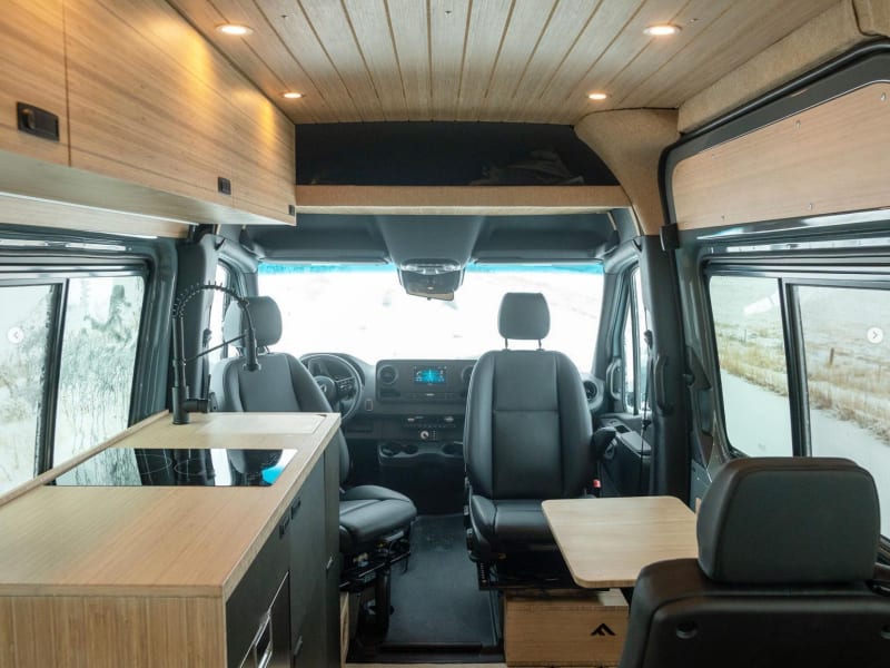 The front seats swivel rearward to create more lounging space in the van. In addition to the large dinette at the back of the van, a small table can be mounted as shown, or between the front seats, for a smaller dining space or a board game.