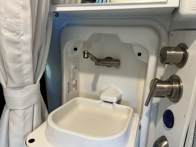 Fold out sink above toilet