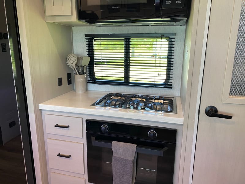 Bake & microwave on the go! This camper kitchen boasts a large convection oven, a gas oven & microwave. Savor tasty treats in the great outdoors!