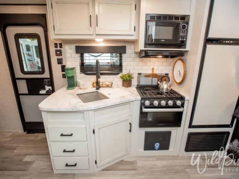 Kitchen Equipped with Stovetop, Oven, Microwave, Refrigerator and Freezer