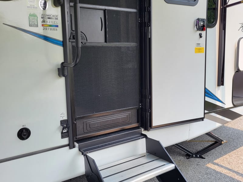 Solid steps fold and lock into doorway  when in tow.  These steps are adjustable for leveling each leg to assist with trailer stability.